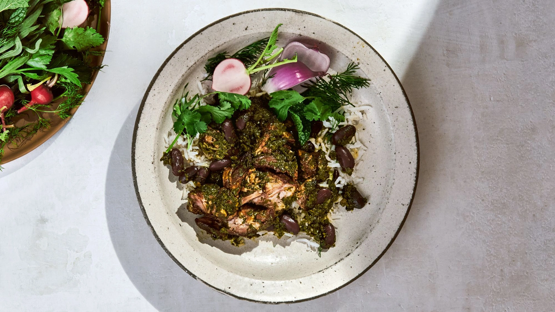 Rich dark green ghormeh sabzi Persian herb stew in copper pot with dried limes and tender lamb at Carnys Restaurant